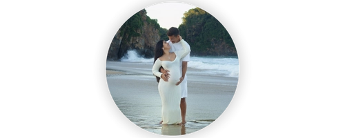 Ensaio de casal gestante na praia com composição romântica e luz natural na Praia Brava.